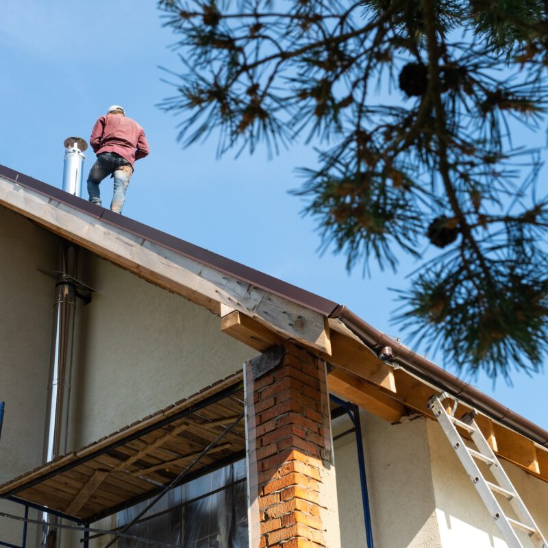 The Master For The Installation Of Ventilation Pipes And The Installation Of The Chimney Of The Furnace Works On The Roof Of The House